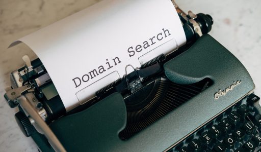 Schreibmaschine mit eingelegtem Blatt, darauf der Text "Domain Search"